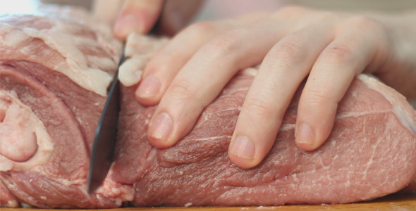 Man Cuts Big Piece of Meat