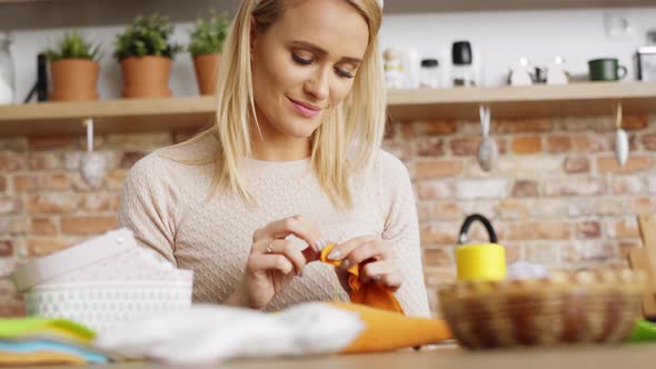 Tilt up video of woman sews in the kitchen. Shot with RED helium camera in 8K.