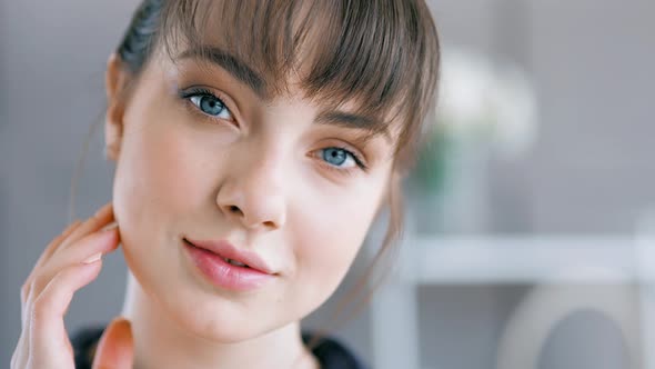 Closeup Portrait Face of Young Attractive European Woman with Dark Hair and Bangs