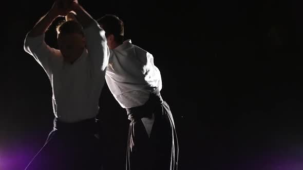 Two Fighters Participants of the Training in Special Clothes of Aikido Hakama Work Out the Methods