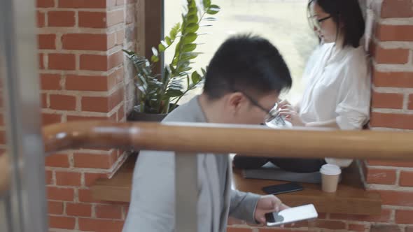 Two Asian Colleagues Working in Office