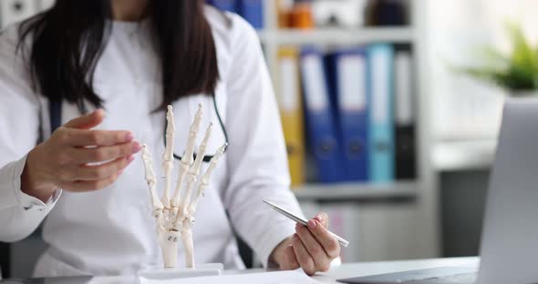 Doctor Shows Anatomy of Hands on Skeleton Closeup