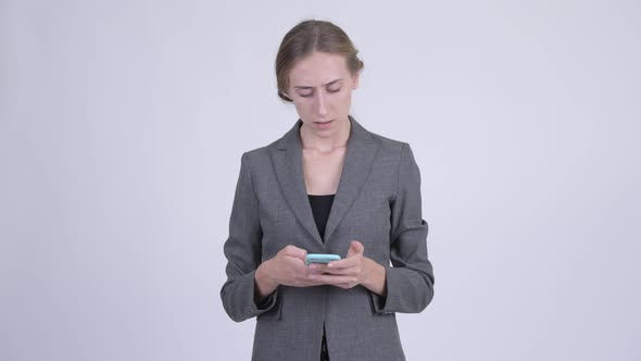 Happy Young Blonde Businesswoman Thinking While Using Phone