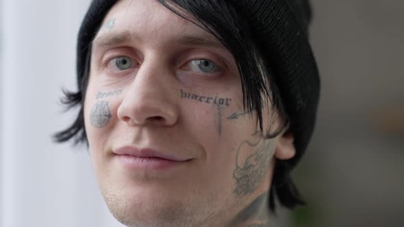 Closeup Portrait of Confident Tattooed Young Man Looking at Camera Smiling