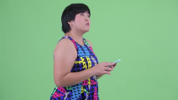 Young Overweight Asian Woman Using Phone As Map