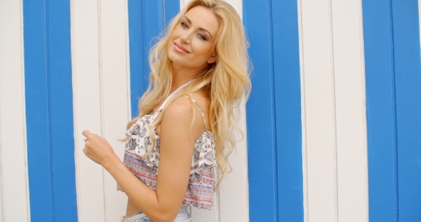 Blond Woman In Front Of Striped Beach House alt