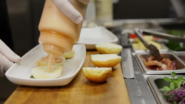 This is a Time Lapse of a chef assembling and plating 3 Slider Cheese Burgers so that they are ready