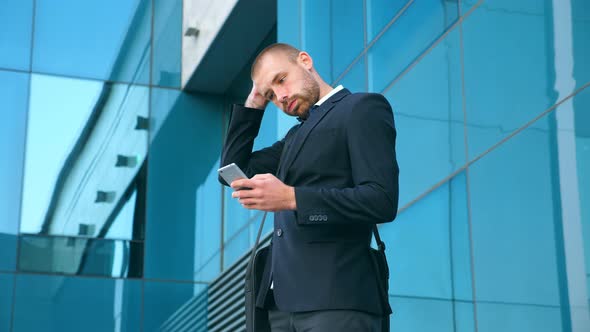 Handsome Businessman Using Smartphone Near Office