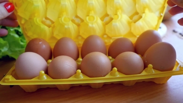 Womans Hands Opens Egg Box And Take