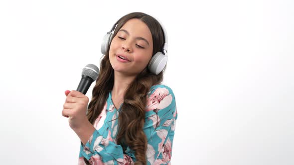 Cheerful Kid Singer Listen Music in Headphones and Sing Song in Microphone Vocal School