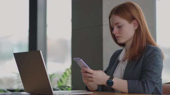 Beautiful Young Business Woman Using Phone in Office