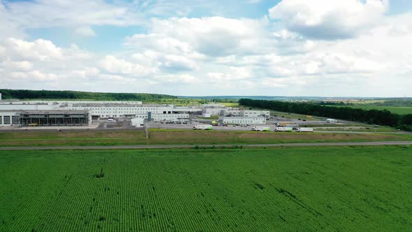 Aerial view of modern storage warehouse with many trucks on parking lot. 