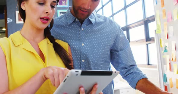 Business executives discussing over digital tablet