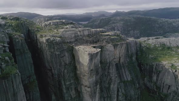 Aerial Slomo flying towards the Preikestolen, Norway, with Tourists on top Walking and Photographing