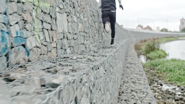 Young Athlete Running Alongside Wall