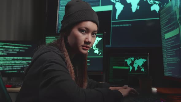 Young Asian Woman Hacker Using Computer Hacking And  Looking, Pose To Camera