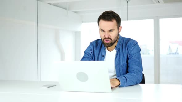 Angry Man Working on Laptop in Office Irritation