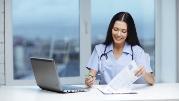 Happy Doctor Or Nurse Signing Medical Documents