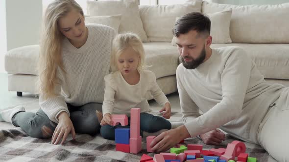 Happy Family with Their Daughter are Relaxing in a Modern Cozy Living Room a Little Daughter and Her