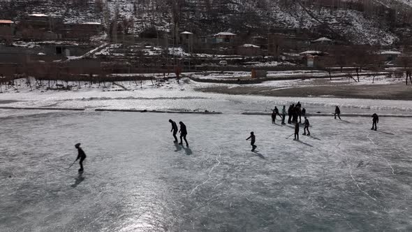 Many people go outside on the frozen lake to ice skate. A 4k cinematic drone shot made in khalti lak