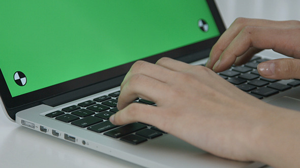Girl Typing on Green Screen Laptop alt