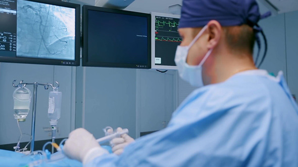 Surgeon Manipulates Medical Equipment