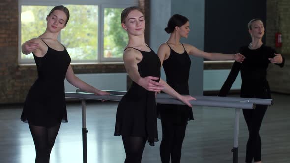 Graceful Ballerinas Exercising at Ballet Barre