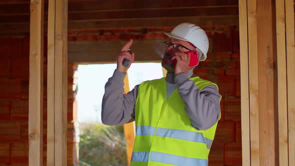 Professional Builder Architect Talking on Mobile Phone to Control Working at Construction Site