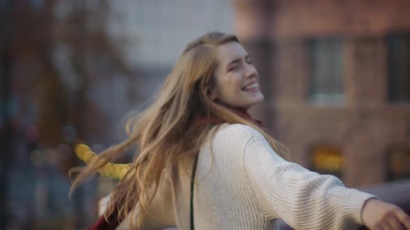 Excited Woman Dancing Outdoors. Cheerful Hipster Girl Whirling on Street.