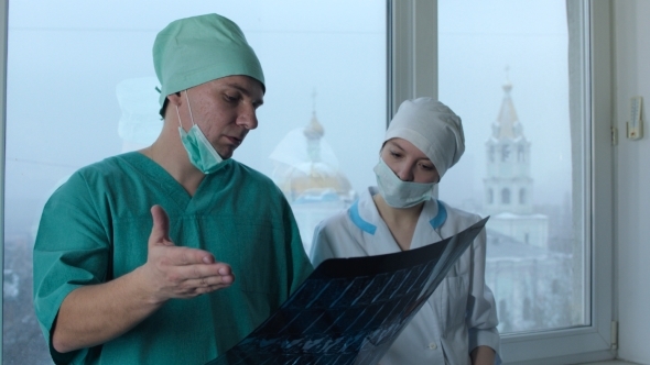 Surgeon And Nurse Arguing The X-Ray Picture