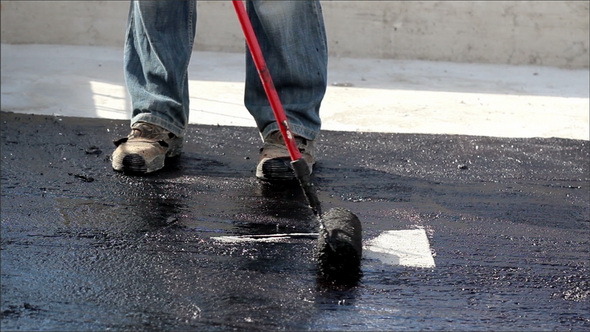 Road Men Manually Applying Asphalt on the Highway