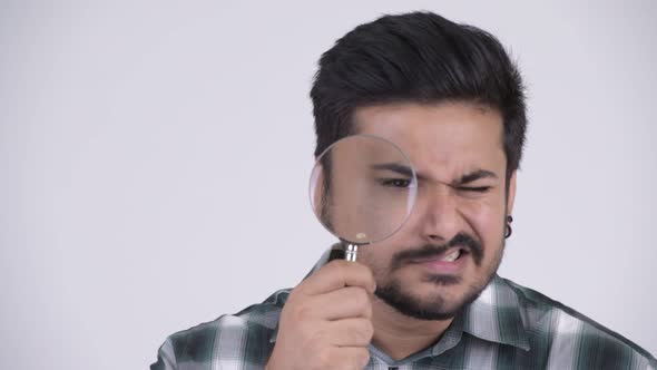 Young Funny Bearded Indian Man Playing with Magnifying Glass