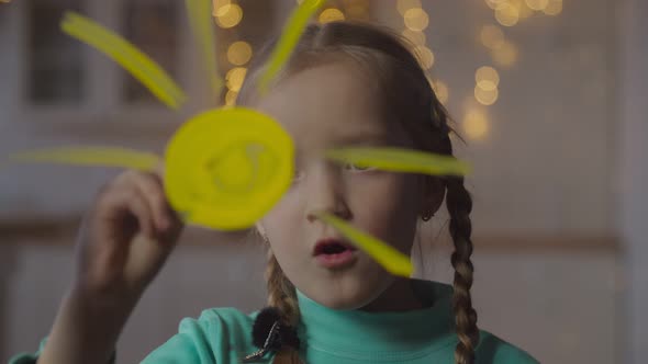 Little Girl Painting Sun on Window Glass at Home