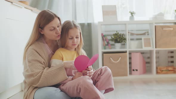 Woman with Her Daughter Looking at Cutout