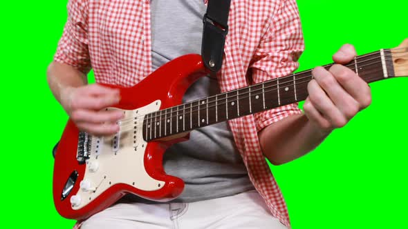 Mid section of male musician playing guitar