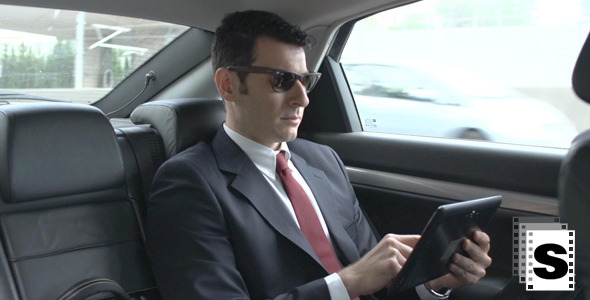 Businessman In Car Using Tablet