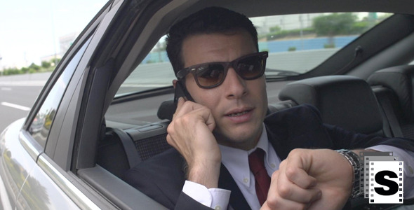 Businessman In Car Using Mobile