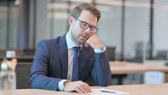 Businessman Taking Nap in Modern Office