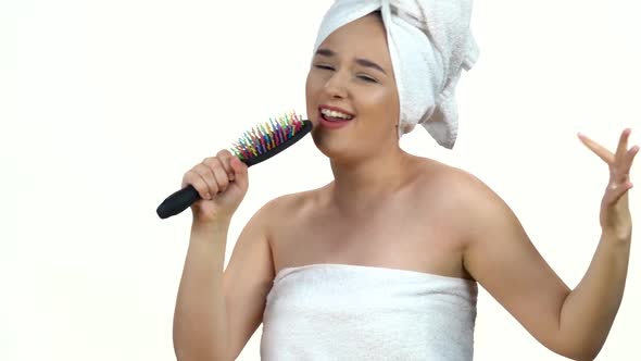 Girl in White Towel on Her Head Dance and Sing Into Comb As in Microphone Isolated on White