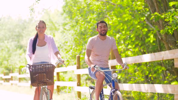 Happy Couple Riding Bicycles at Summer Park