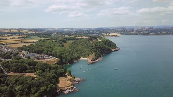 Aerial view of cove beach in Brixham England. Boats are docked near shore at the cove beach.