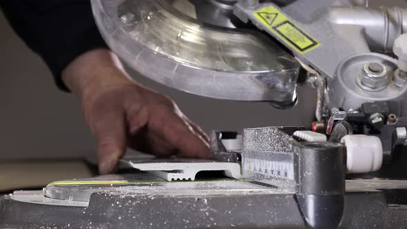 Worker cutting baseboard on the circular saw before installing.