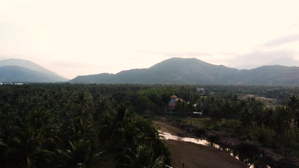 aerial view of rural village Cam Ranh in jungle rainforest of vietnam, drone fly above mountains lan