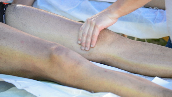 Physiotherapist Massaging Leg of an Athlete