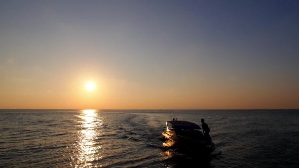 Motor Boat Sailing At Sea Against Sunset