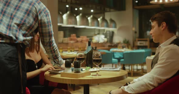 Beautiful Couple in Love is Sitting in a Cozy Cafe