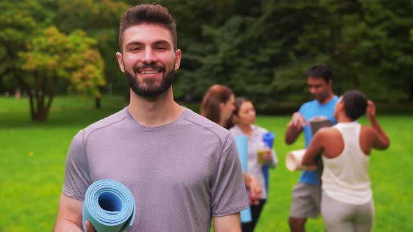 Smiling Man with Yoga Mat Over Group of People