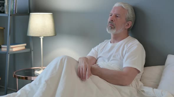 Pensive Old Man Thinking in Bed