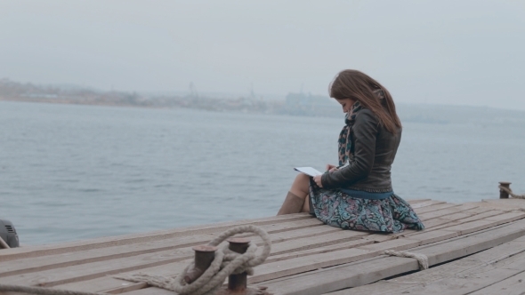 Romantic Girl In Skirt Sitting On The Pier Near