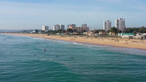 Aerial View of Beautiful Portuguese Beaches with Tourists Surfers Boarding in the Algarve in the